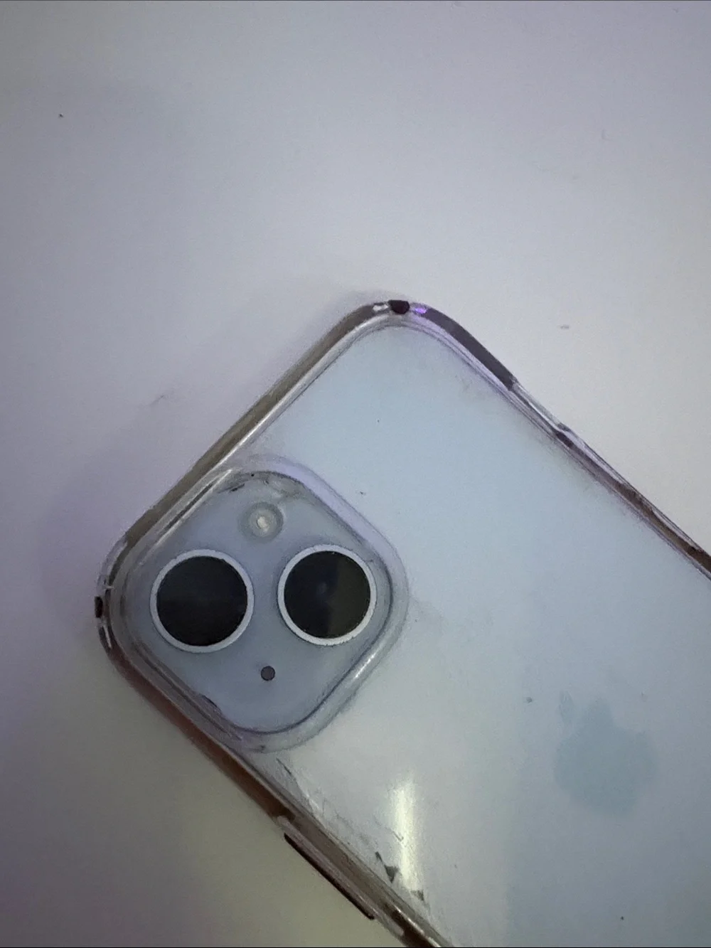 Apple iPhone 15, light blue with clear case.